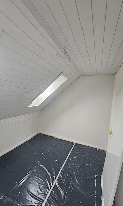 Dachzimmer mit Holzdecke und sauberer Wandfläche
